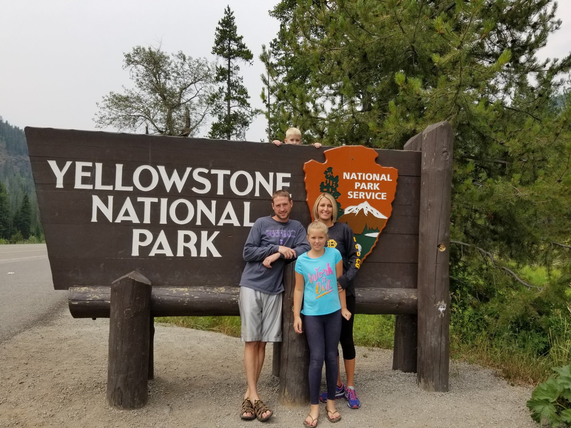 Our Family standing in front of the Yellowstone National Park Sign
