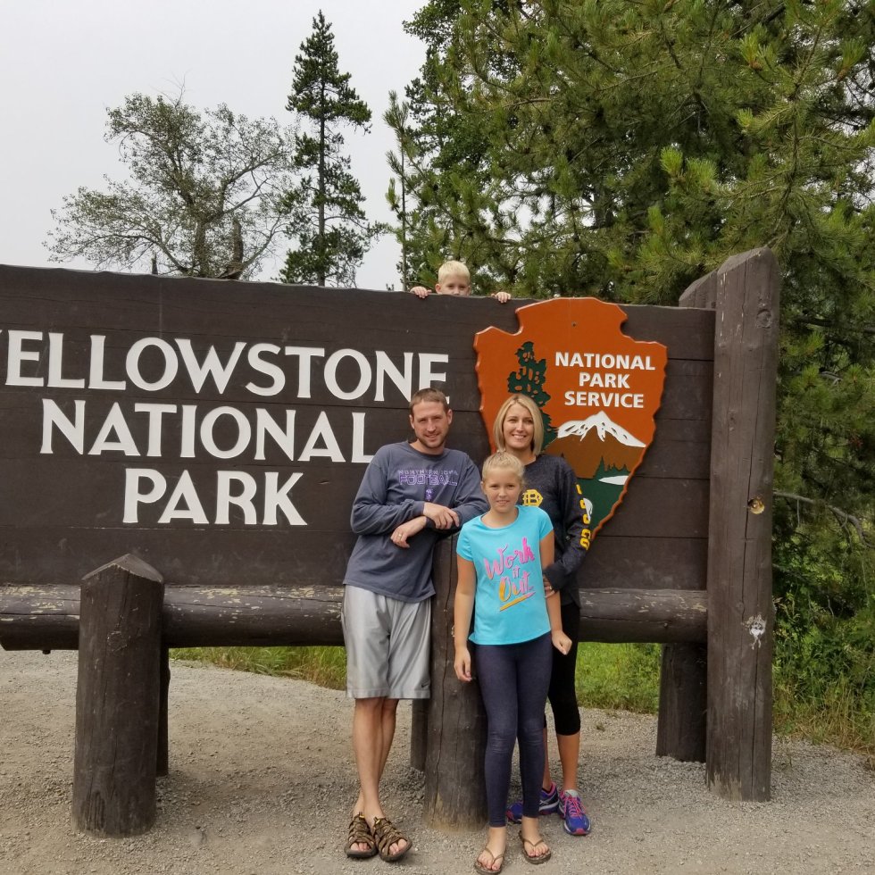 Our Family standing in front of the Yellowstone National Park Sign
