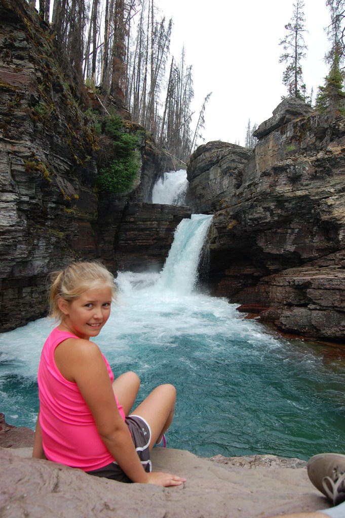 A girl in a pink shirt next to rushing water