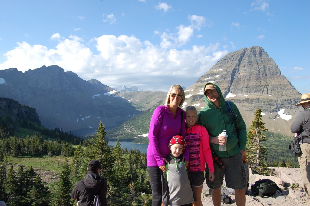 A family photo in front of a grand landscape of Hidden Lake