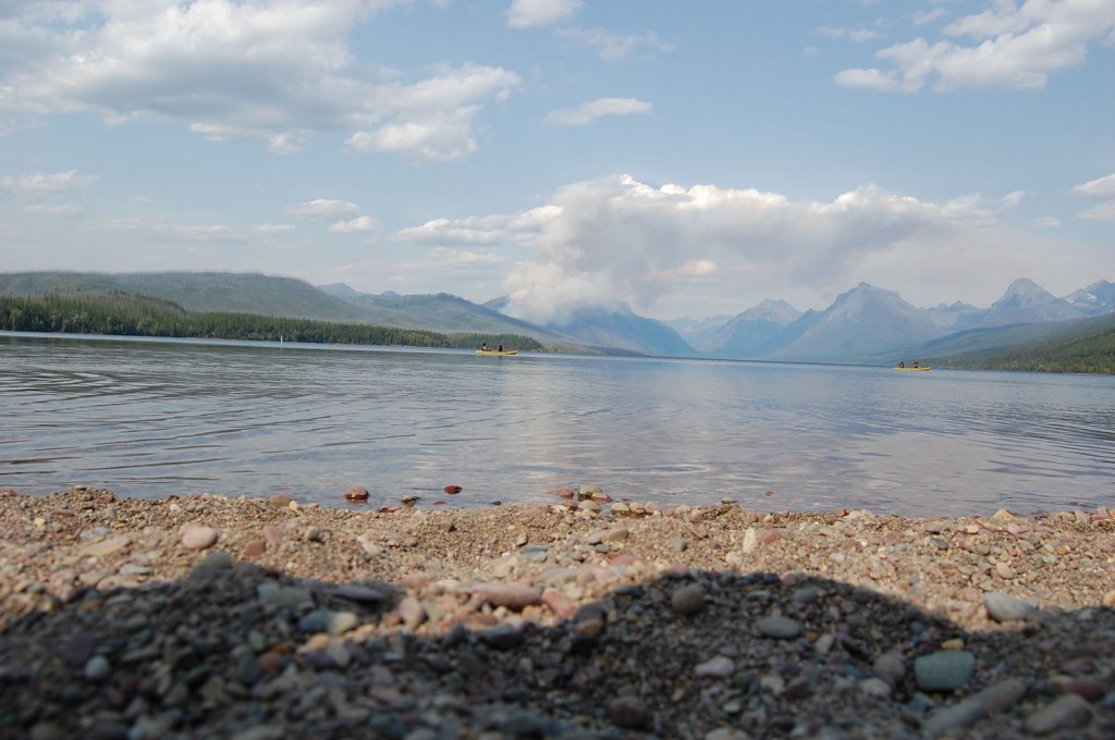 Pebbles, a lake, and mountains at Glacier Park