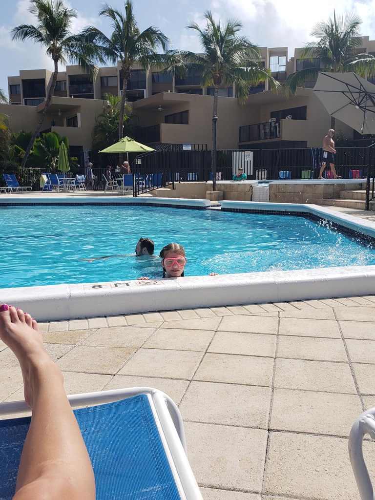 Girl peeking her head over the side of a pool