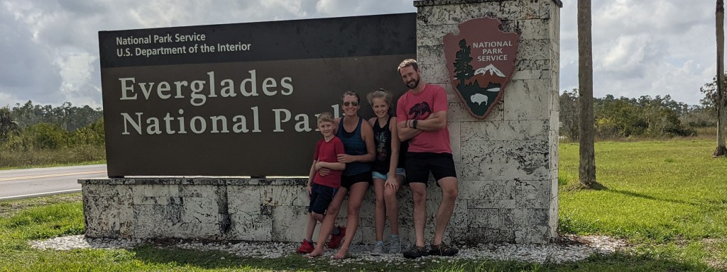 Family standing in front of the Everglades National Park sign