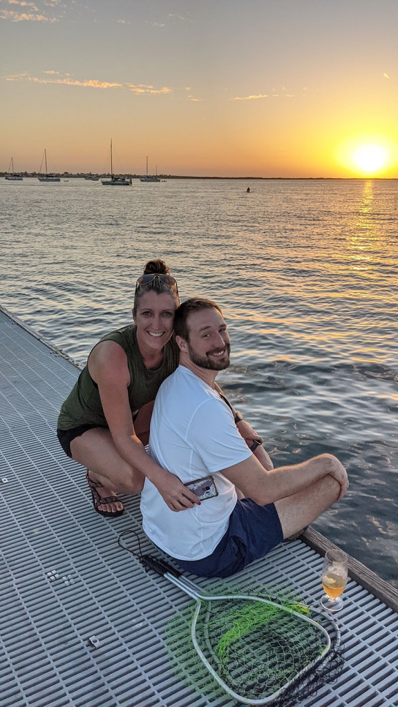 A couple hugs on the dock at sunset