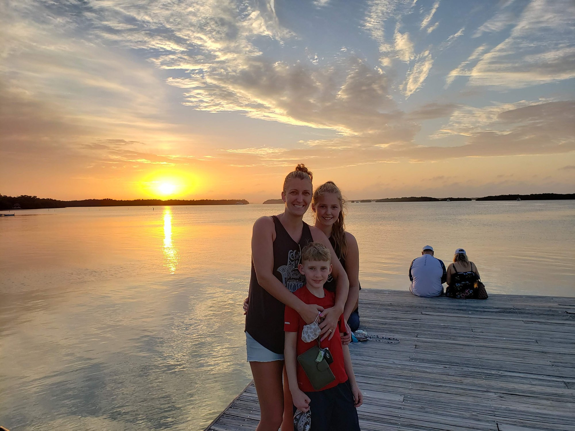 Family in front of a sunset on a dock