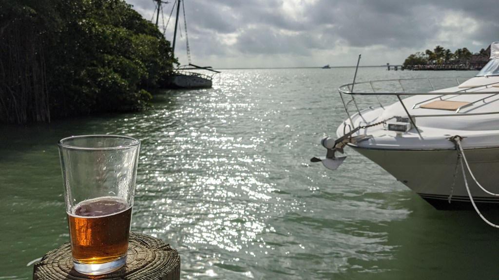 A beer on the dock overlooking a shipwreck in the bay