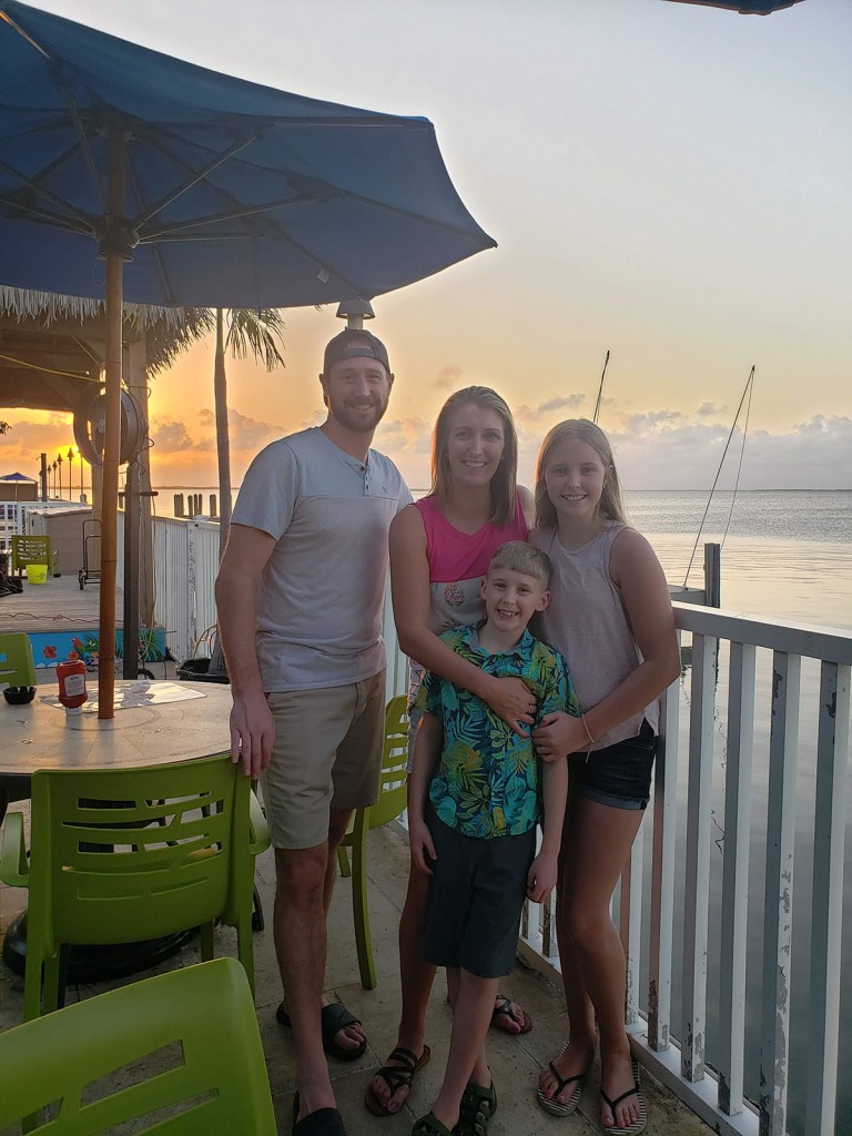 A family of four in front of a sunset