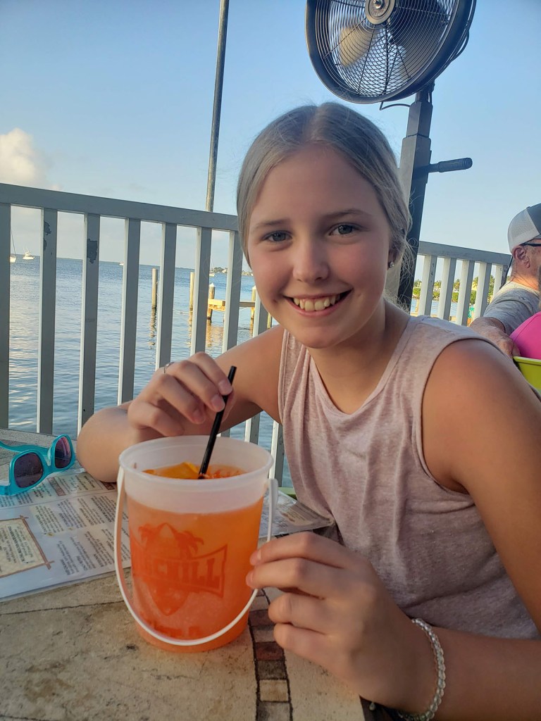 A young girl smiling with a large drink