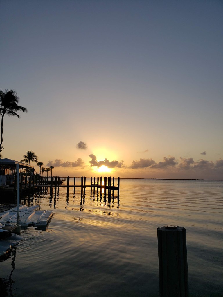 Sun setting over a dock in the bay