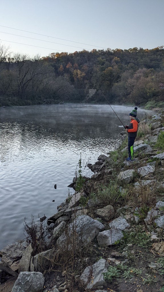 A boy fishing from the river bank of Pulpit Rock Campground
