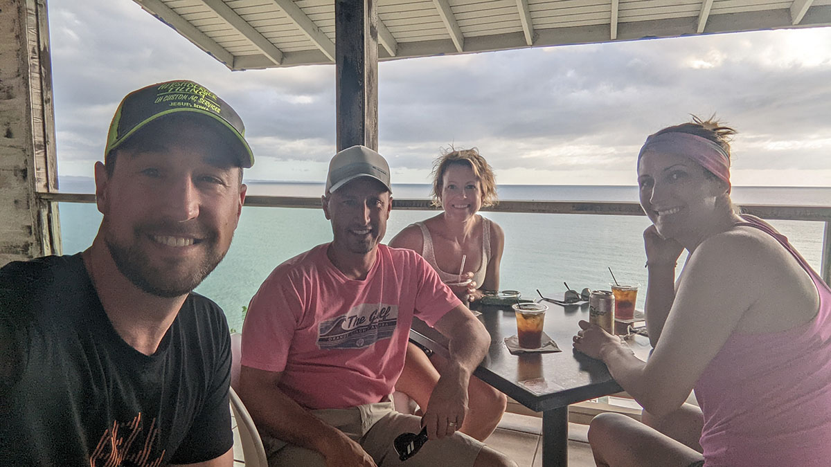 2 couples having drinks on the patio by the ocean