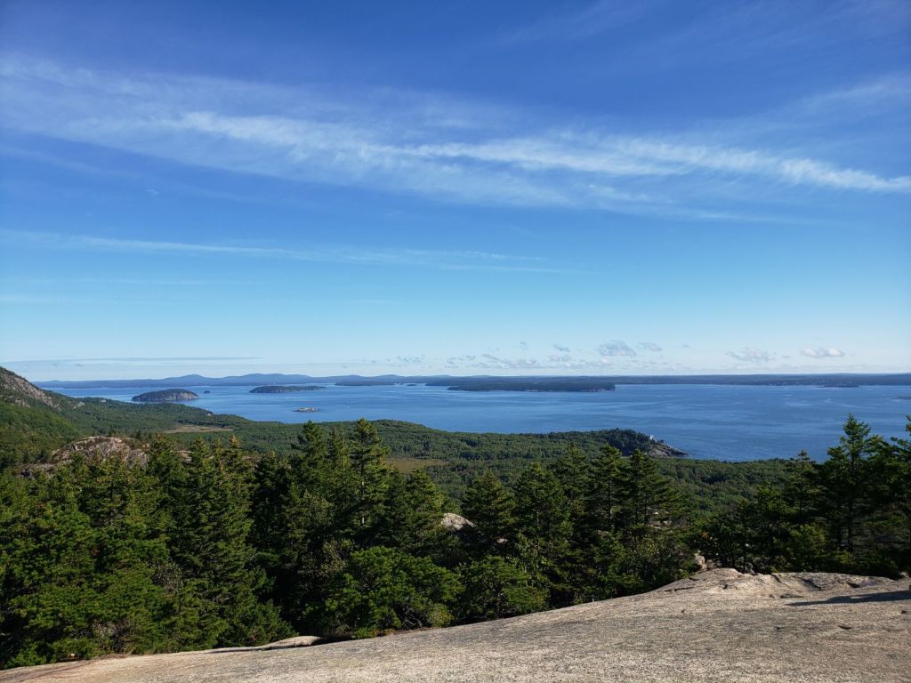 Islands pepper the blue ocean with a blue sky