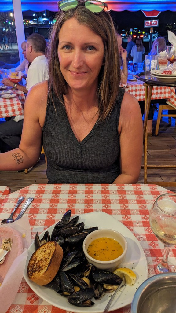 Mussels and butter on a plate sitting on a red and white checkered table