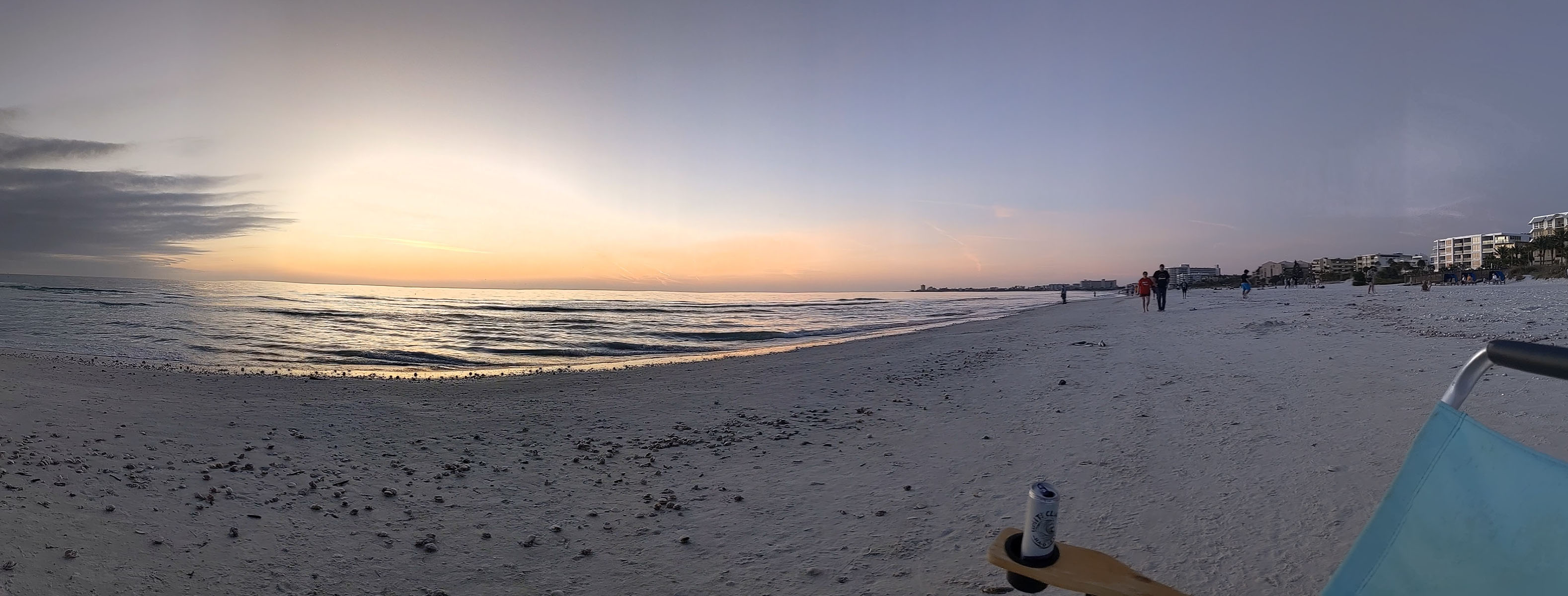 The sandy beach with the sun setting in a background