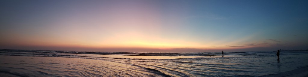 A panoramic view of Crescent Beach at sunset.