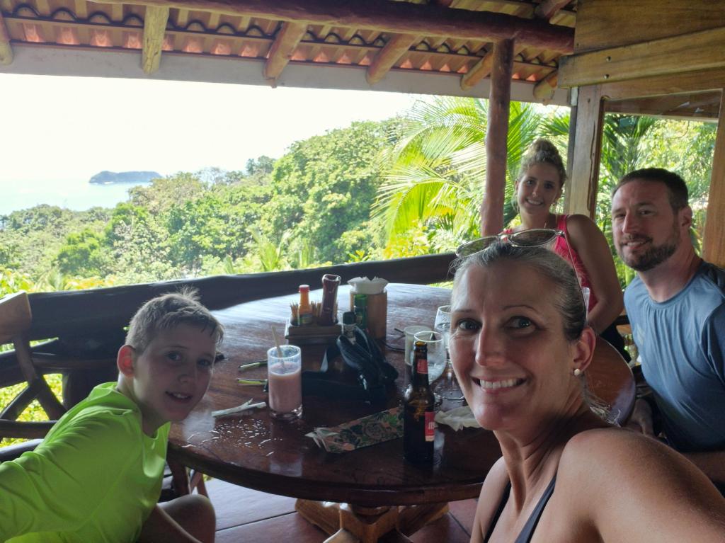 A family of four smiles at their table