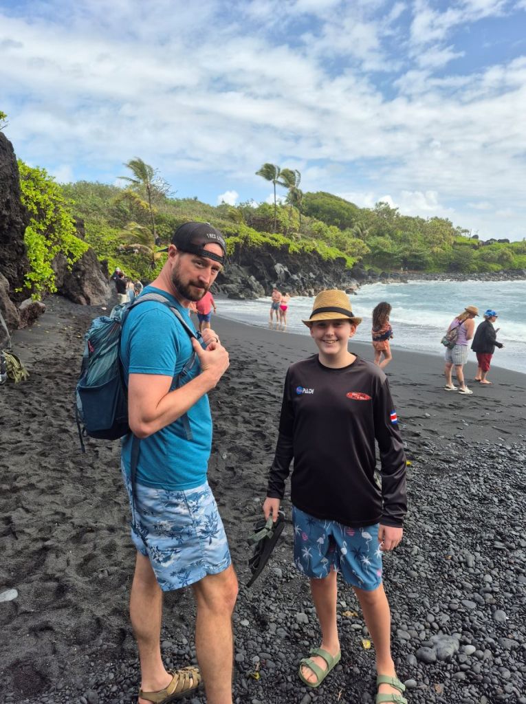 Mattix and I at the black sand beach smiling, ready for adventure.