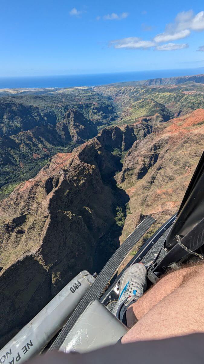 A reddish brown ridge towers above a dark shadowy valley