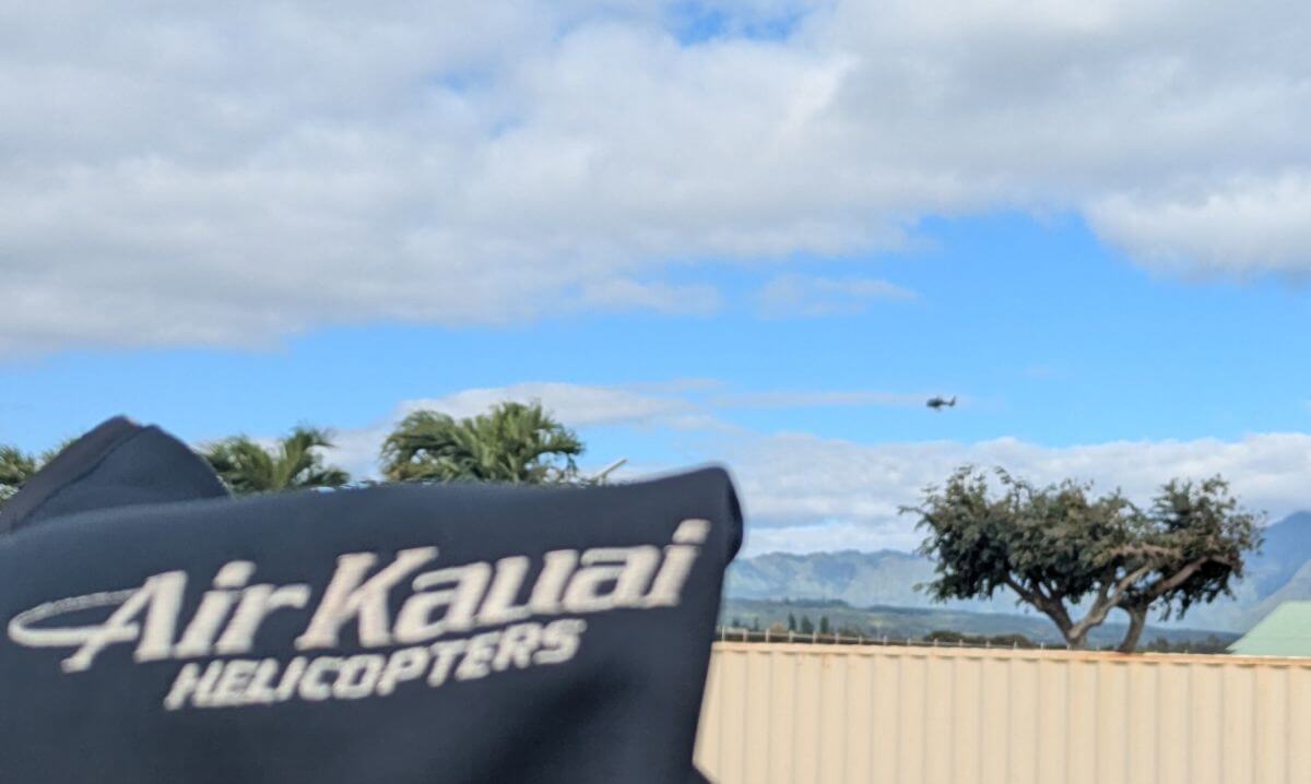 The logo for Air Kauai Helicopters with a helicopter in the background