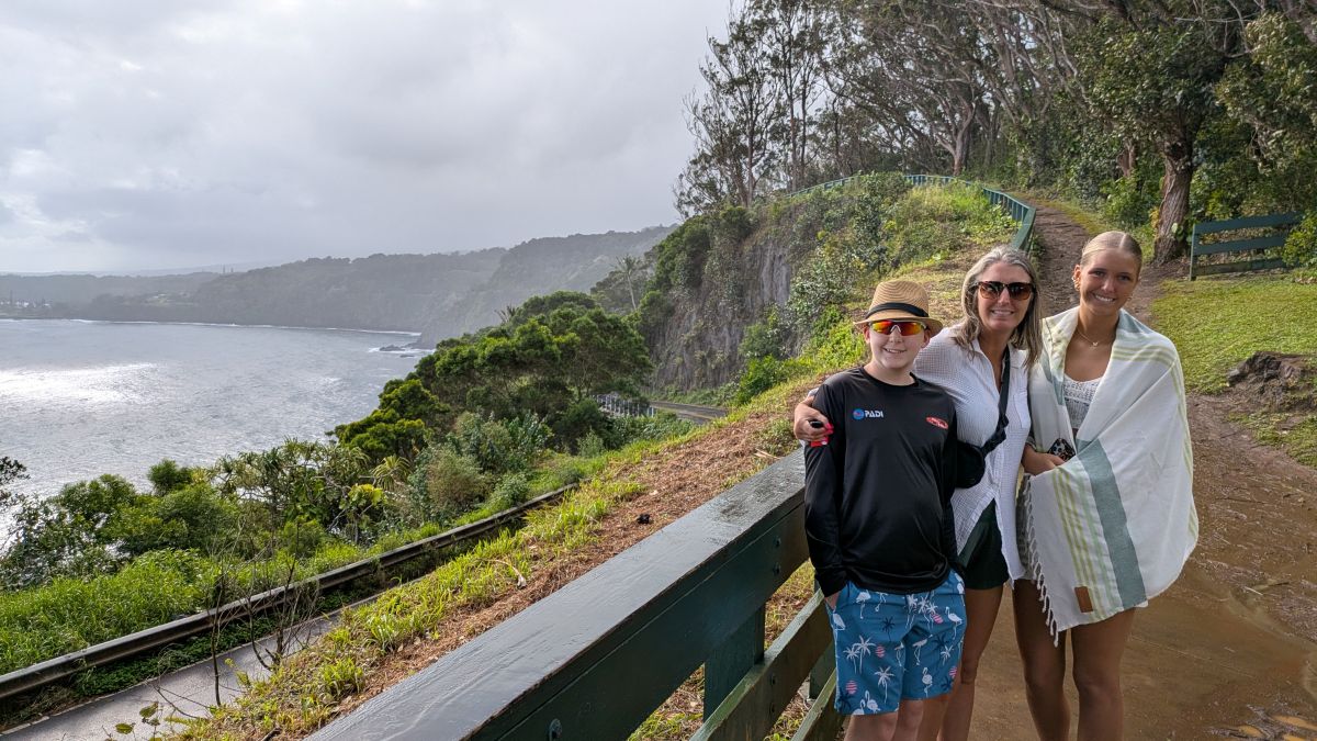 Family in front of the cliffs at one of the stops on the Road to Hana.