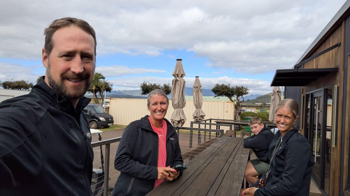 A family of four smiles at the camera on a deck awaiting their adventure