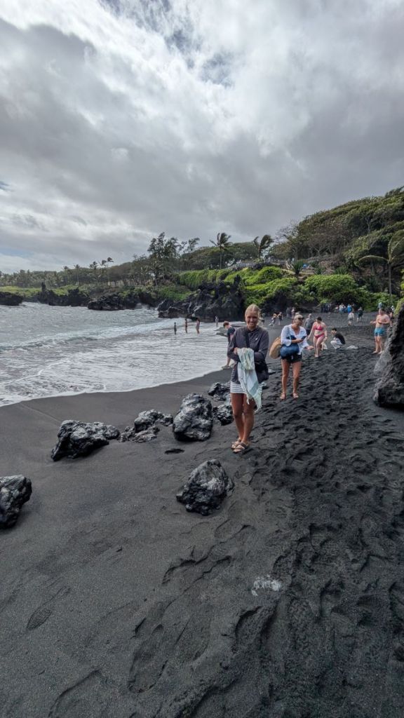 Charlie and Jill walking along the black sand at Waianapanapa State Park