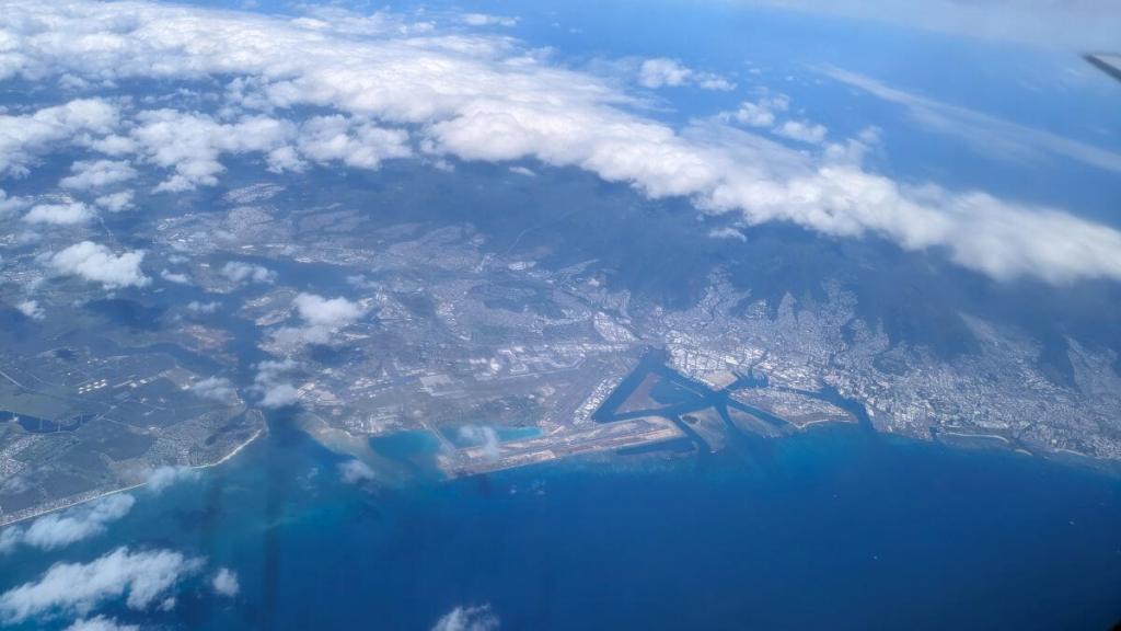 The island of Oahu from our plane. Pearl Harbor can be seen from behind a few clouds.